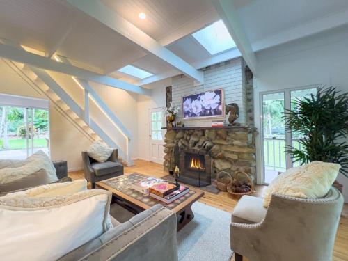 een woonkamer met open haard en tv bij The Gingerbread House in Upper Tallebudgera