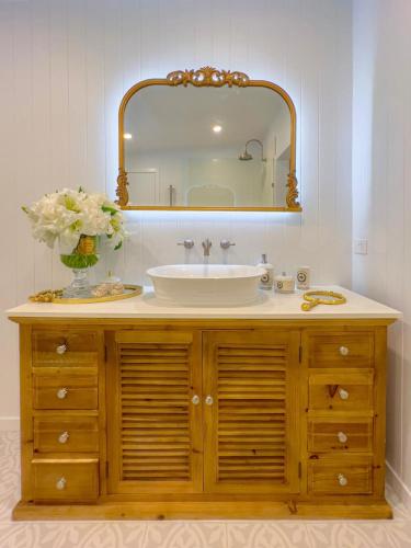a bathroom with a sink and a mirror at The Gingerbread House in Upper Tallebudgera