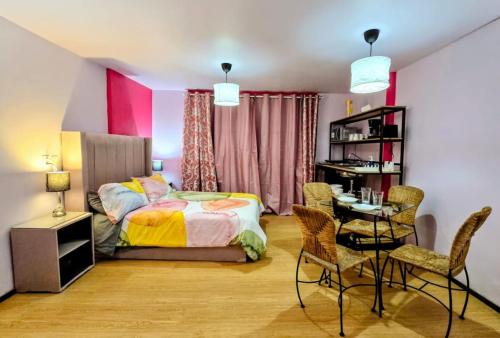 a bedroom with a bed and a table and chairs at Suite Rosa familiar para hasta 6 huéspedes Amplia, céntrica, con cocineta y baño privado in Mexico City