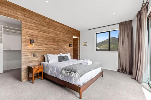 a bedroom with a large bed and a window at Luxury Hāwea, Alfresco Retreat, Sleeps 6 in Lake Hāwea
