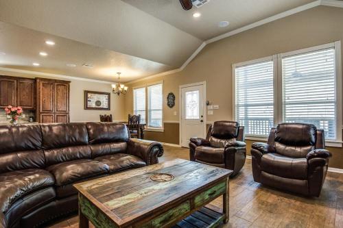een woonkamer met een leren bank en 2 stoelen bij River Ridge on the Guadalupe - Riverfront with Large Deck, Direct Float Access & Cliff Side Views in New Braunfels
