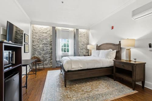 een slaapkamer met een bed, een bureau en een tafel bij Sonoma Stonehouse Suite 10 in Bak