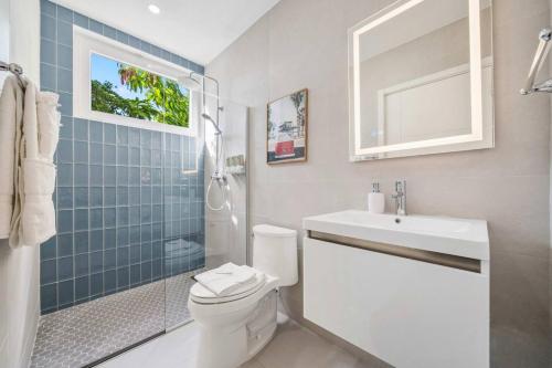 ein Badezimmer mit Toilette, Waschbecken und Dusche in der Unterkunft DayDream Villa in Palm-Eagle Beach