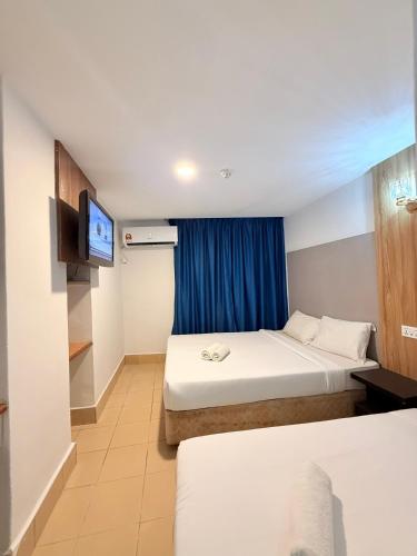 a hotel room with two beds and a television at Hotel Putra Hills at WTCKL in Kuala Lumpur