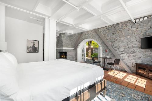 een slaapkamer met een groot bed en een stenen muur bij Sonoma Stonehouse Hotel in Bak