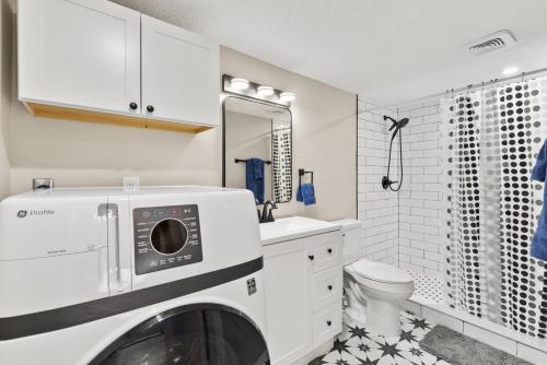 a white bathroom with a washer and dryer in it at IMG Condo Near Golf Course in Bradenton