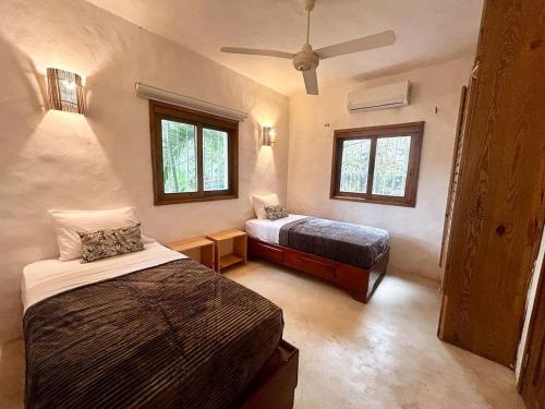 a bedroom with two beds and a ceiling fan at Villa Las Malaguenas in Las Terrenas