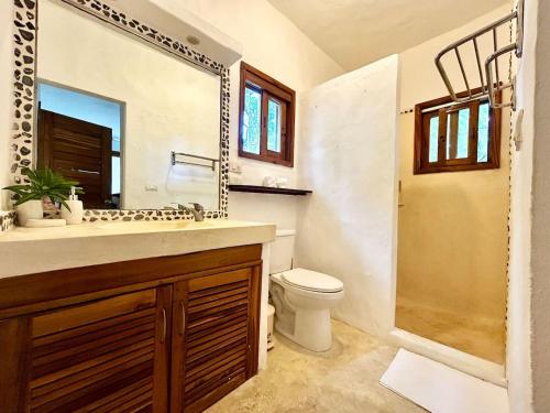 a bathroom with a sink and a toilet and a mirror at Villa Las Malaguenas in Las Terrenas