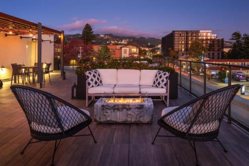 two chairs and a couch on a balcony with a fire pit at Aiden by Best Western Berkeley in Berkeley