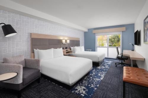 a hotel room with a large white bed and a couch at Aiden by Best Western Berkeley in Berkeley
