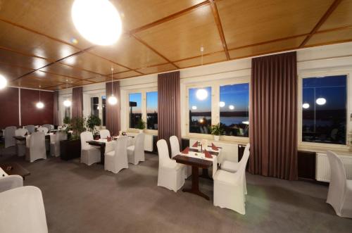 ケルブラにあるLand-gut-Hotel Barbarossaの白い椅子とテーブル、窓のあるレストラン