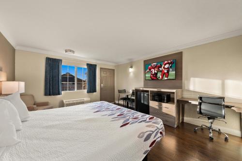 a hotel room with a bed and a desk at Red Roof Inn Los Angeles - Bellflower in Bellflower