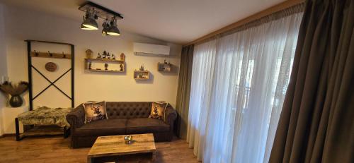 una sala de estar con un sofá y una mesa en Amore Grande, en Beli Iskar