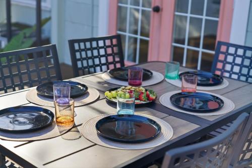 a wooden table with plates of food on it at Spacious Modern Farmhouse w/ Private Patio & BBQ! in Tampa
