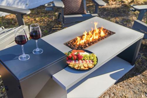 a table with two glasses of wine and a plate of fruit at Spacious Modern Farmhouse w/ Private Patio & BBQ! in Tampa