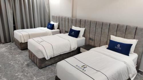 2 bedden in een hotelkamer met blauwe kussens bij فندق جولدن نيو جوان HOTEL GOLDEN NEW jWan in Abha
