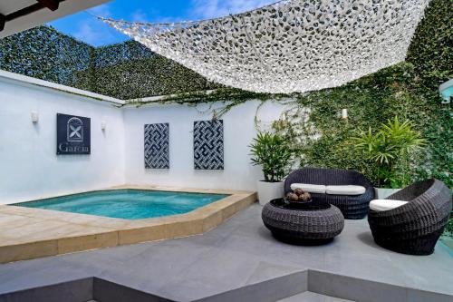 a patio with a swimming pool and two chairs at Casa García in Guayaquil