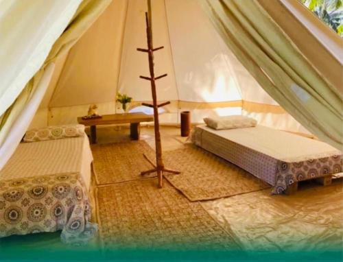 een tent met twee bedden en een tafel erin bij Bio-Resort Camping in Trairi