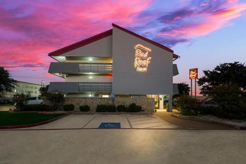 a building with a sign on the side of it at Red Roof Inn Dallas - DFW Airport North in Irving