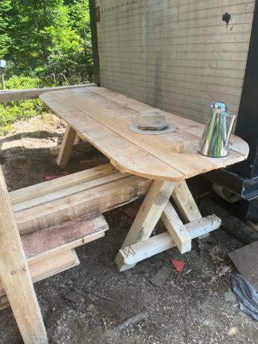 un tavolo da picnic in legno con sopra un bollitore per il tè di Adriana Phoenix's Bird a Horezu