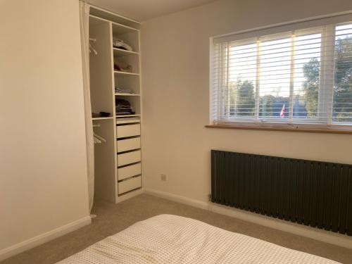 a white room with a closet with a window at Comfortable Homestay by Earith Lakes in Earith