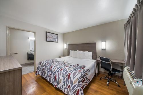 a hotel room with a bed and a desk at Red Roof Inn San Antonio E - Frost Bank Center in San Antonio