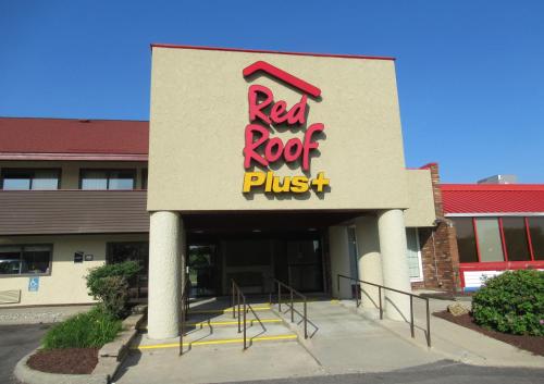 a building with a red rock pizza sign on it at Red Roof Inn PLUS+ Ann Arbor - U of Michigan North in Ann Arbor