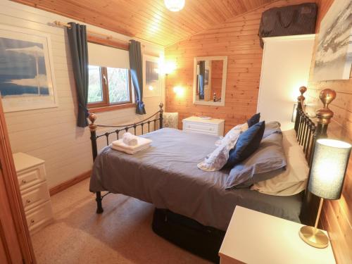 a bedroom with a bed in a wooden room at Lamorna in Penzance