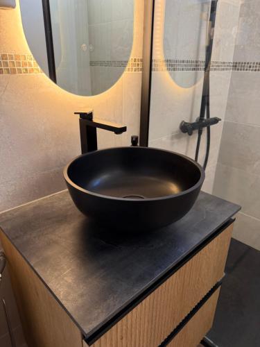 ein schwarzes Waschbecken auf einer Theke in einem Badezimmer in der Unterkunft Comfortable apartment with sea view in Le Barcarès