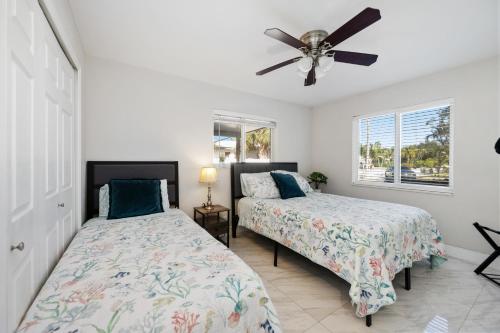 una camera da letto con due letti e un ventilatore a soffitto di Villa Hanna a Lighthouse Point