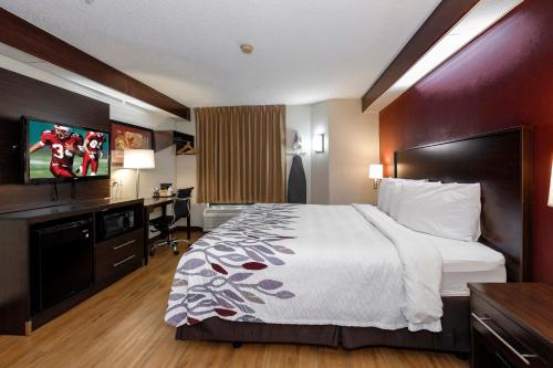 a hotel room with a bed and a desk at Red Roof Inn Pensacola Fairgrounds in Pensacola