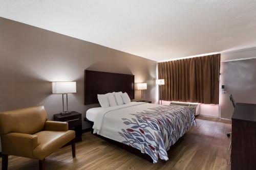 a hotel room with a bed and a chair at Red Roof Inn Columbia, SC Airport in Columbia