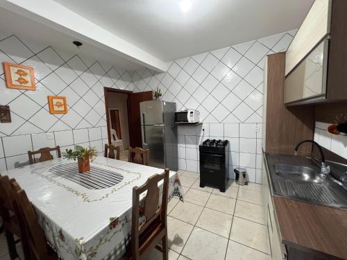 een keuken met een tafel en een koelkast bij Casa Brisa do Siriú in Garopaba