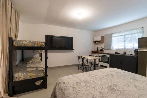 una camera con letto a castello e una cucina di Kitnet 03 Pet friendly com Wi-Fi e Garagem a Bragança Paulista