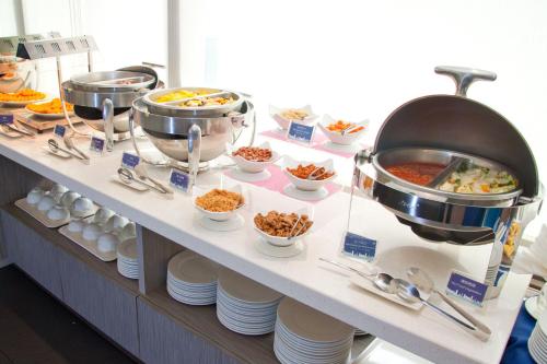 a buffet line with food and bowls of food at Holiday Inn Express Taoyuan by IHG in Taoyuan