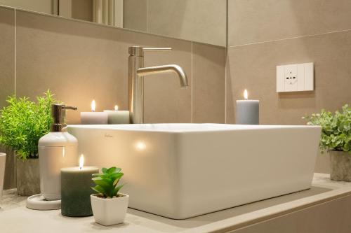 een badkamer met een witte wastafel en kaarsen op het aanrecht bij Orta Paradise 26 in Orta San Giulio