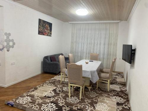 a dining room with a table and chairs and a couch at Дом в Гусаре in Qusar