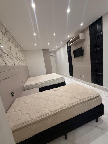 una camera da letto con due letti e una TV a schermo piatto di Casa estrada 6 a Bertioga