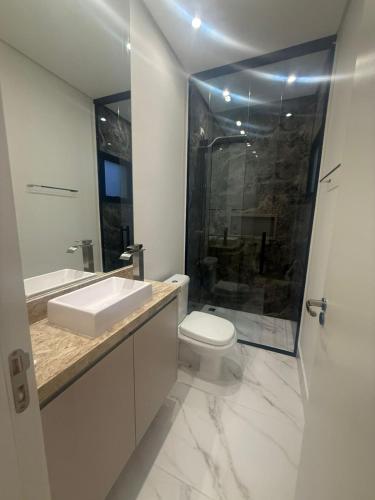 un bagno con wc, lavandino e doccia di Casa estrada 6 a Bertioga