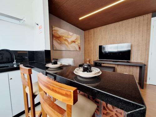 a kitchen with a table and chairs and a television at LK Barro Preto 16 in Belo Horizonte