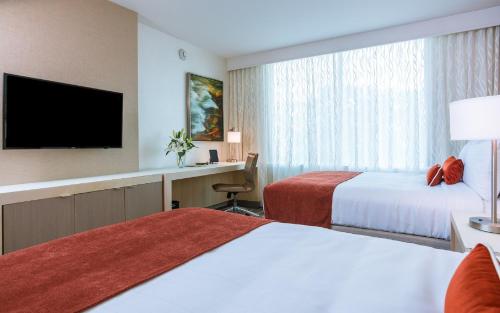 a hotel room with two beds and a flat screen tv at Mohegan Sun in Uncasville