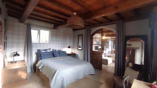 une chambre avec un grand lit avec des oreillers bleus dans l'établissement Le Clos de Marenla, à Marenla