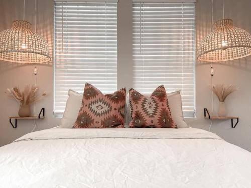 een slaapkamer met een bed met kussens en 2 lampen bij - The Magnolia - Fort Worth TX - Same Day Booking in Fort Worth