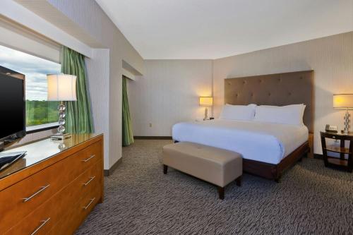 a hotel room with a bed and a flat screen tv at Hotel Auburn Hills in Auburn Hills