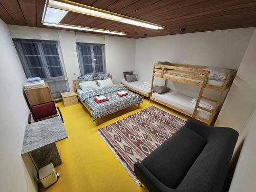 a room with a couch and bunk beds in it at Privat Grosse Zimmer, Mars, mit gemeinsamer Küche und Bad in Altstadt Chur in Chur