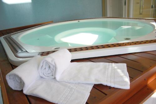 a bathroom with a jacuzzi tub with two rolled towels at Marsala Apart Hotel in Mogi das Cruzes