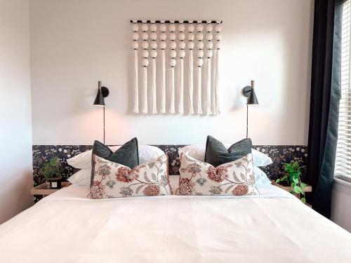 een slaapkamer met een wit bed met kussens bij Central 1B1B Studio - Magnolia - Hospital District in Fort Worth