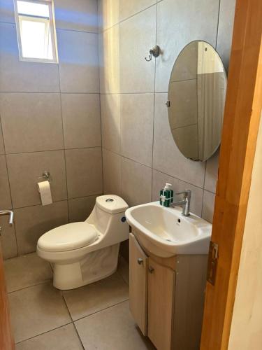 un bagno con un water, un lavandino e uno specchio di Hermosos Departamentos en La Serena a La Serena