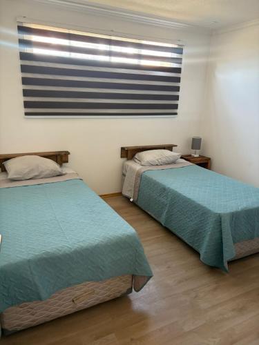 una camera da letto con due letti e una finestra con una bandiera americana di Hermosos Departamentos en La Serena a La Serena