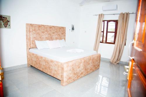 een slaapkamer met een bed, een bank en een raam bij Spice Garden Lodge B&B in Zanzibar City